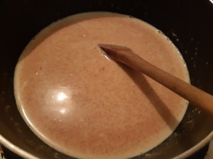 lait concentré et lait mélangés avec praliné de noisettes mis à chauffer dans une casserole